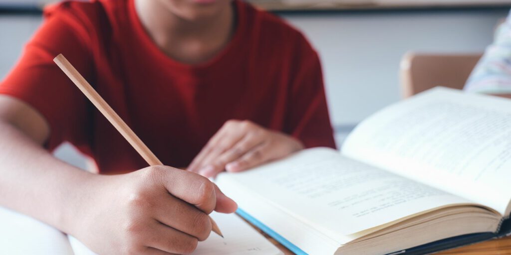 Student working at a desk in a classroom.