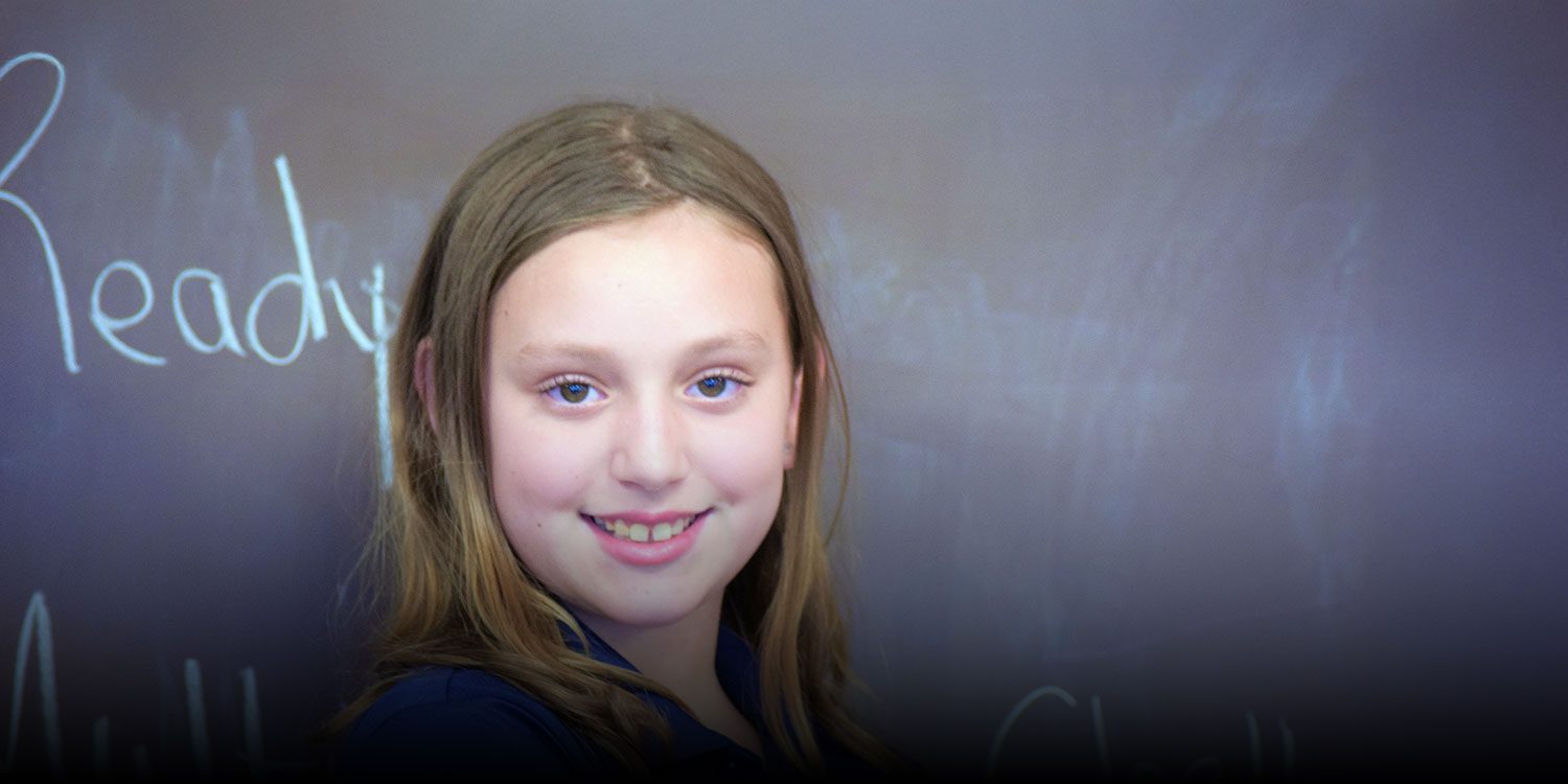 Smiling student in a classroom.