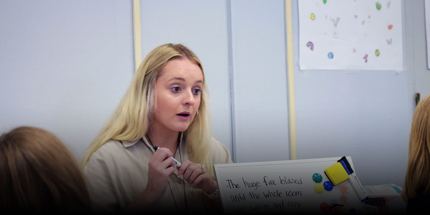 Teacher engaging in a lesson with a small group in a classroom.
